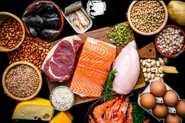 Assorted protein-rich foods on wooden board.