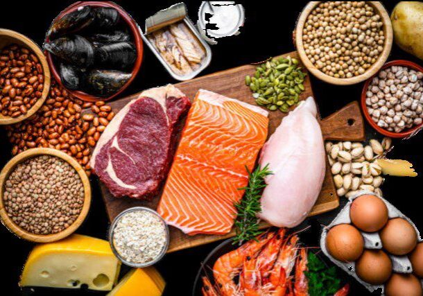 Assorted protein-rich foods on wooden board.